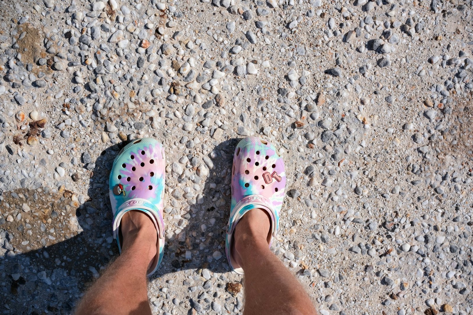 Colourful clogs decorated with butterfly charms on gravel