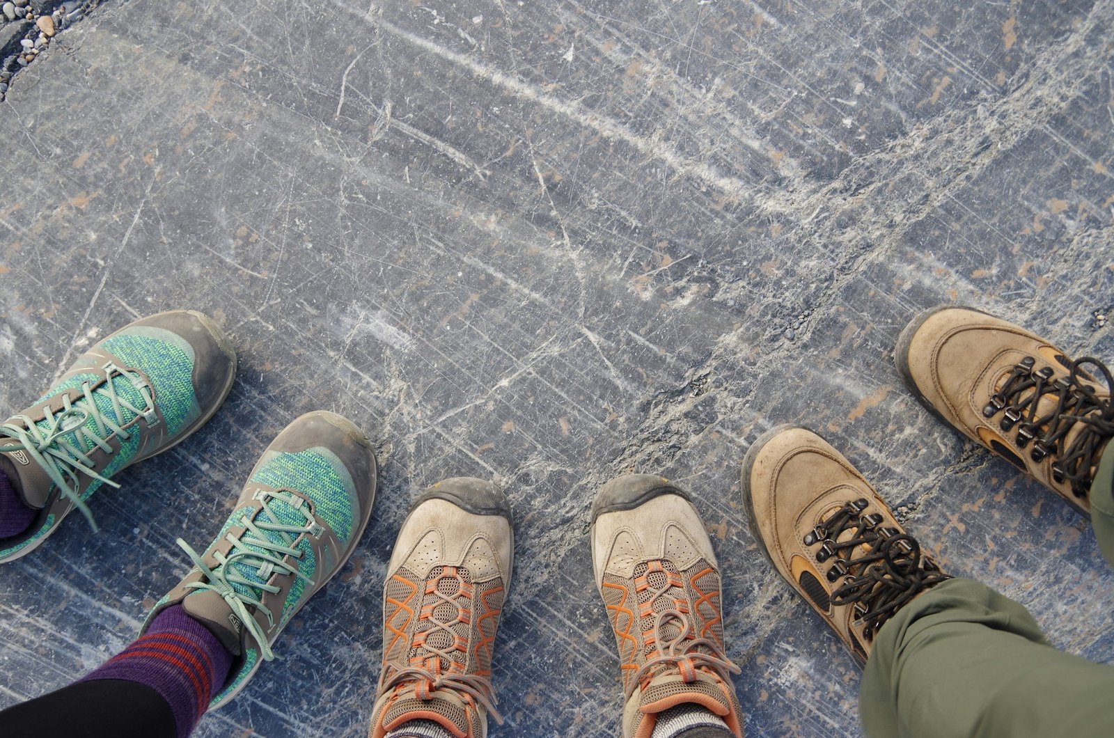 Three people showing their sneakers