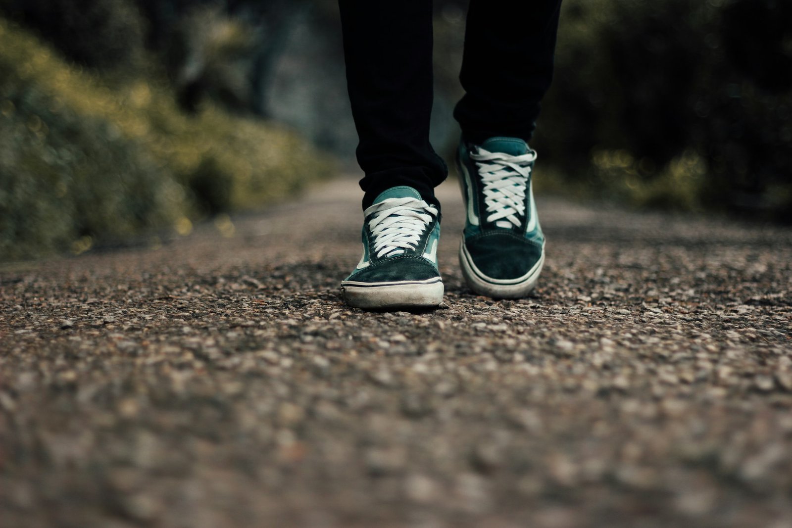 Person standing on a gravel road in walking shoes